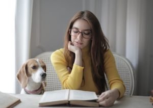 a girl studying with her beagle dog