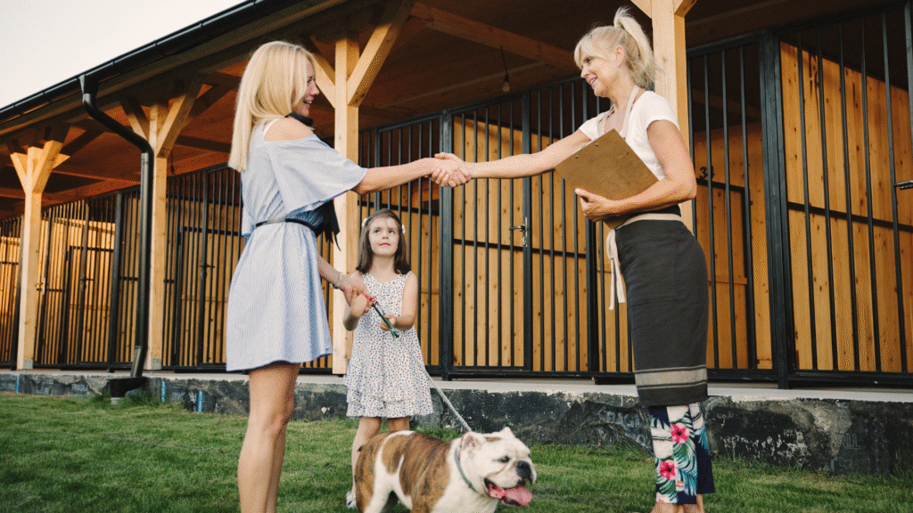 dog parent and dog trainer shaking and at dog boarding center